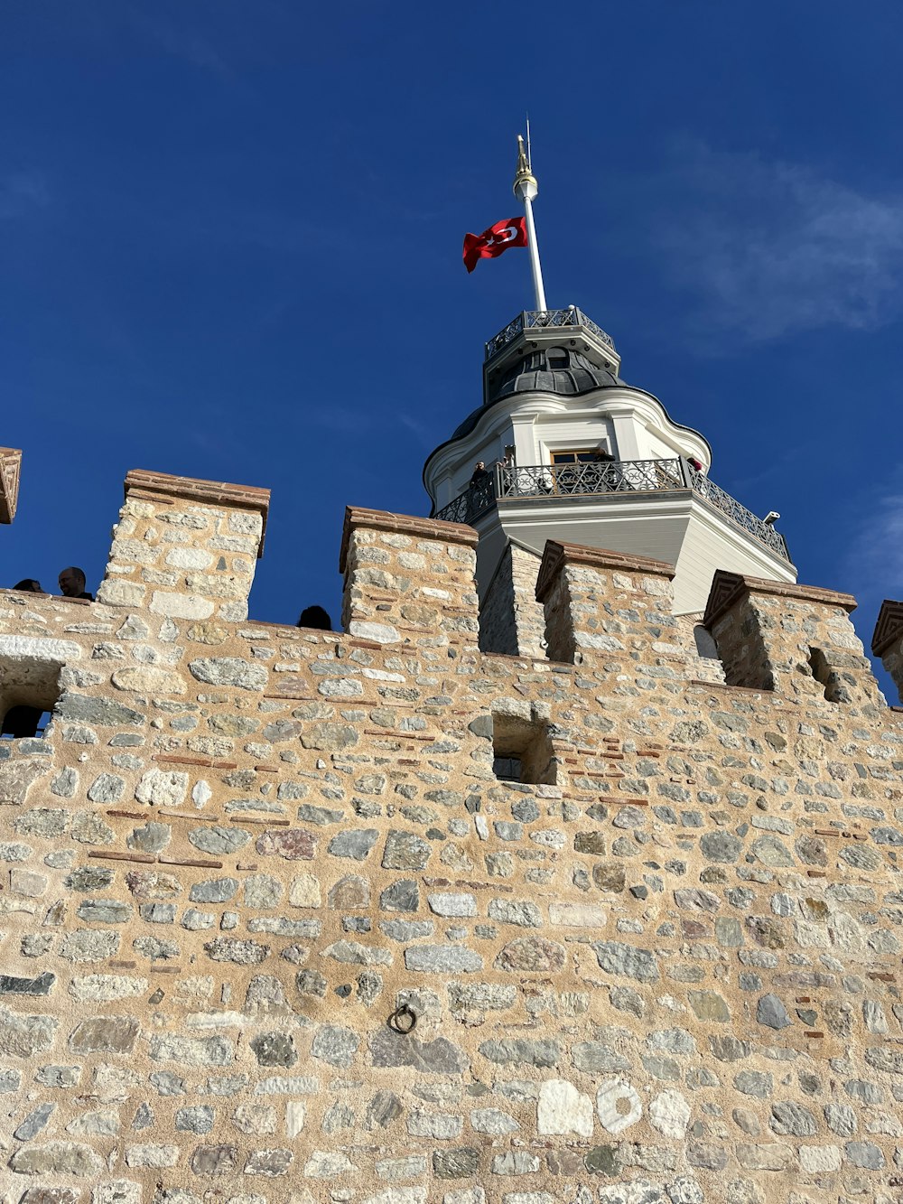 ein hohes Backsteingebäude mit einer Flagge auf der Spitze