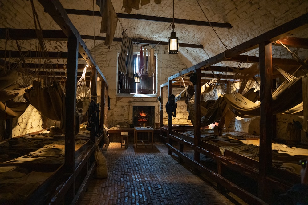 a room filled with lots of beds covered in blankets