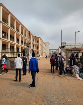 A bustling street scene in Aden with local people engaging in daily activities under a bright sky.