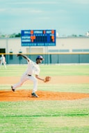 a baseball player pitching a ball on top of a field