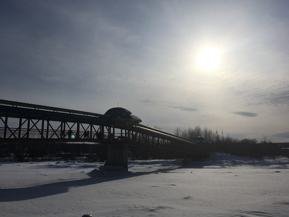 a train traveling over a bridge in the snow