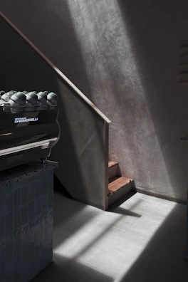 Dimly lit atelier corner with vintage coffee tools and a faint glow highlighting textures.