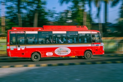 An electric bus weaving through busy Hong Kong streets with lush greenery lining the route.
