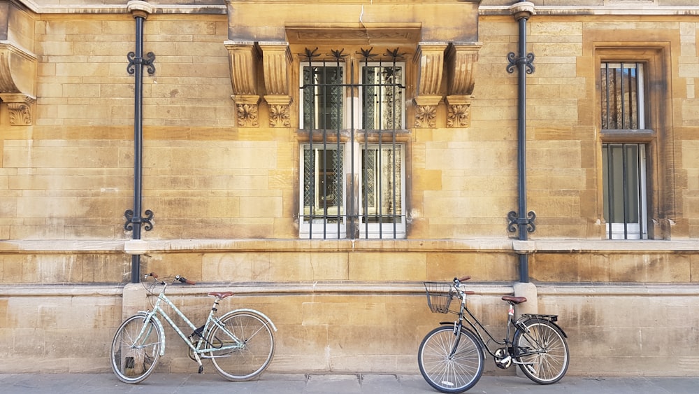 two bicycles parked next to each other in front of a building