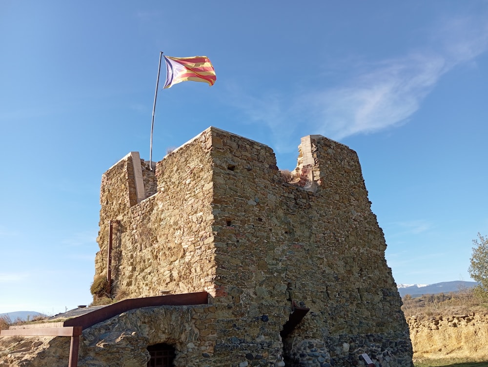 a flag flying on top of a stone building