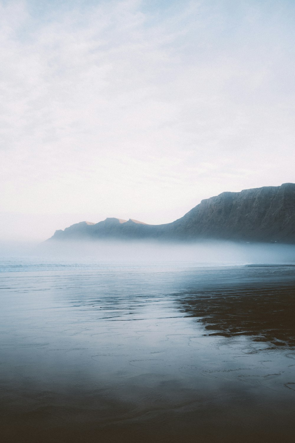 a body of water with a mountain in the background