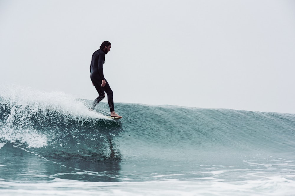 a man riding a wave on top of a surfboard