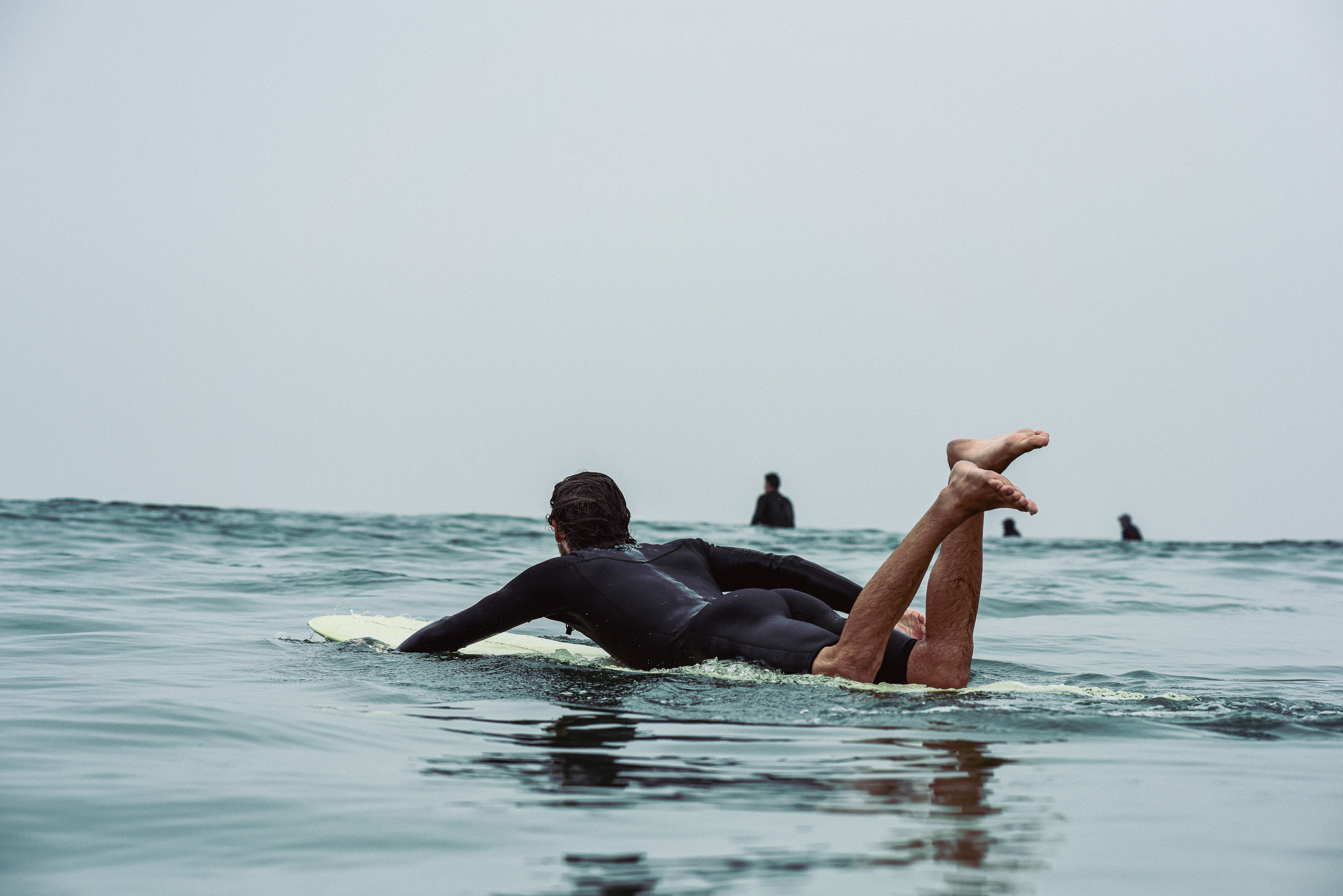 a man laying on a surfboard in the ocean