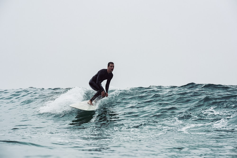 a man riding a surfboard on top of a wave