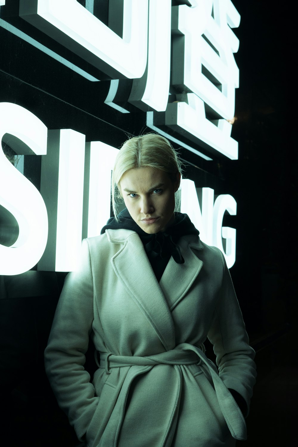 a woman standing in front of a neon sign