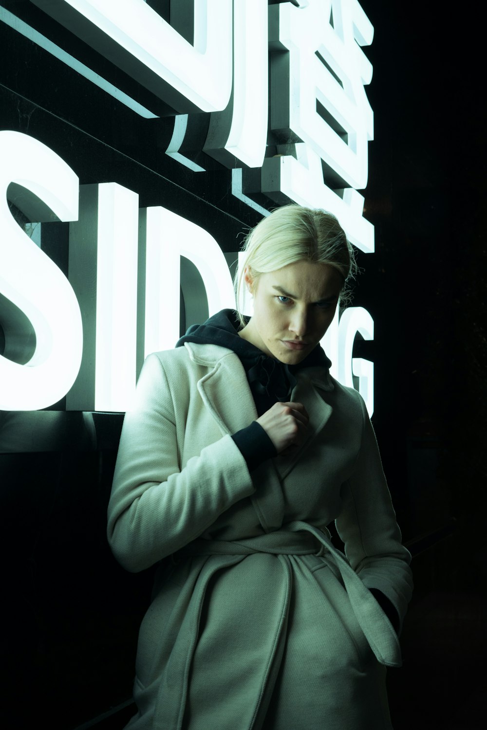 a woman standing in front of a neon sign