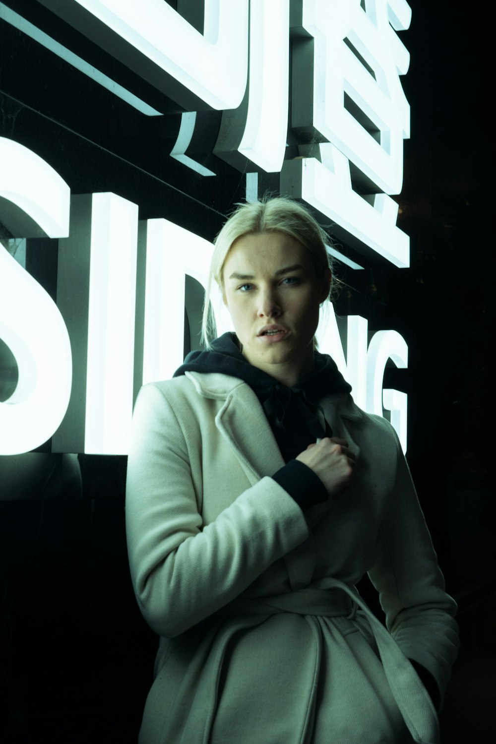 a woman standing in front of a neon sign