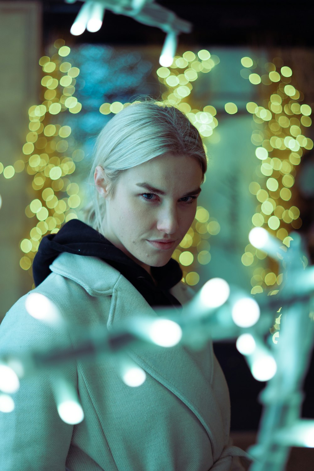 a woman in a white coat looking at her cell phone