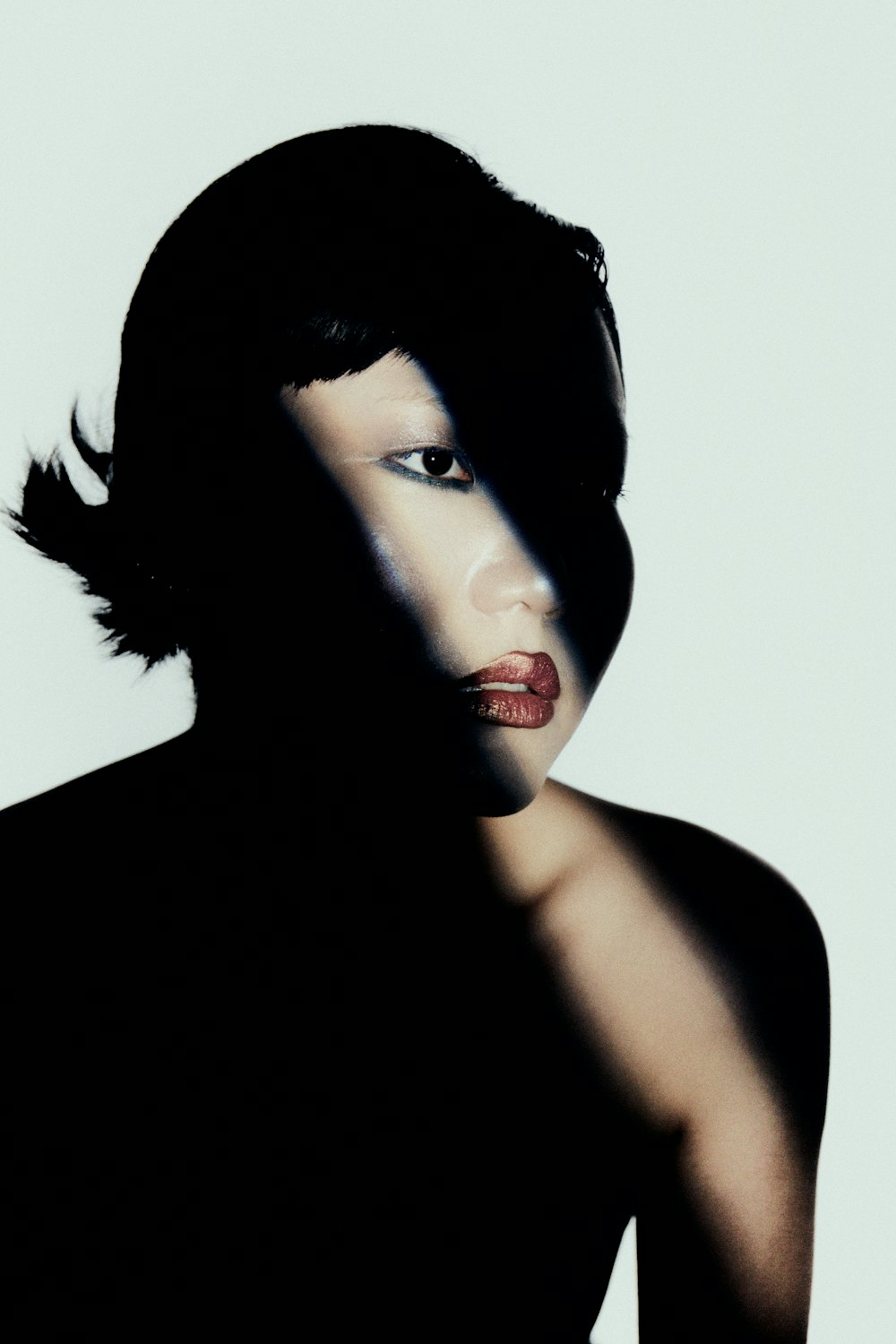 a woman in a black dress with a shadow on her face