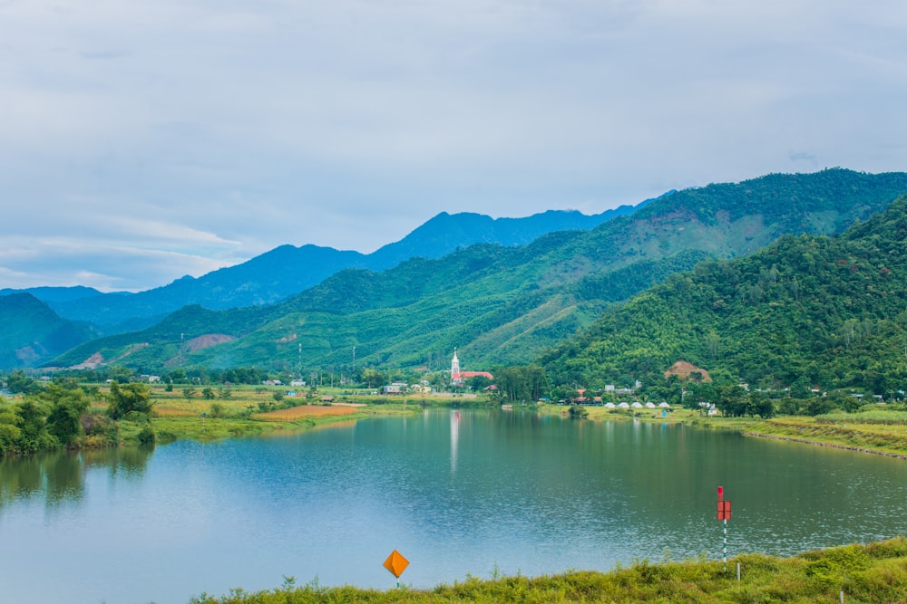 a body of water surrounded by a lush green hillside