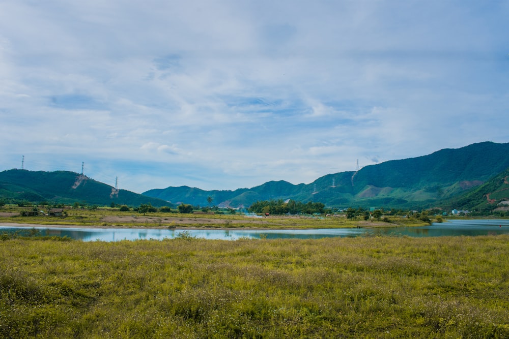 a grassy field with mountains in the background