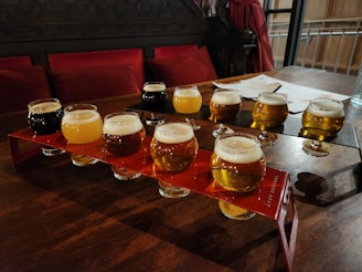 An assortment of craft beers in various glasses on a wooden table.
