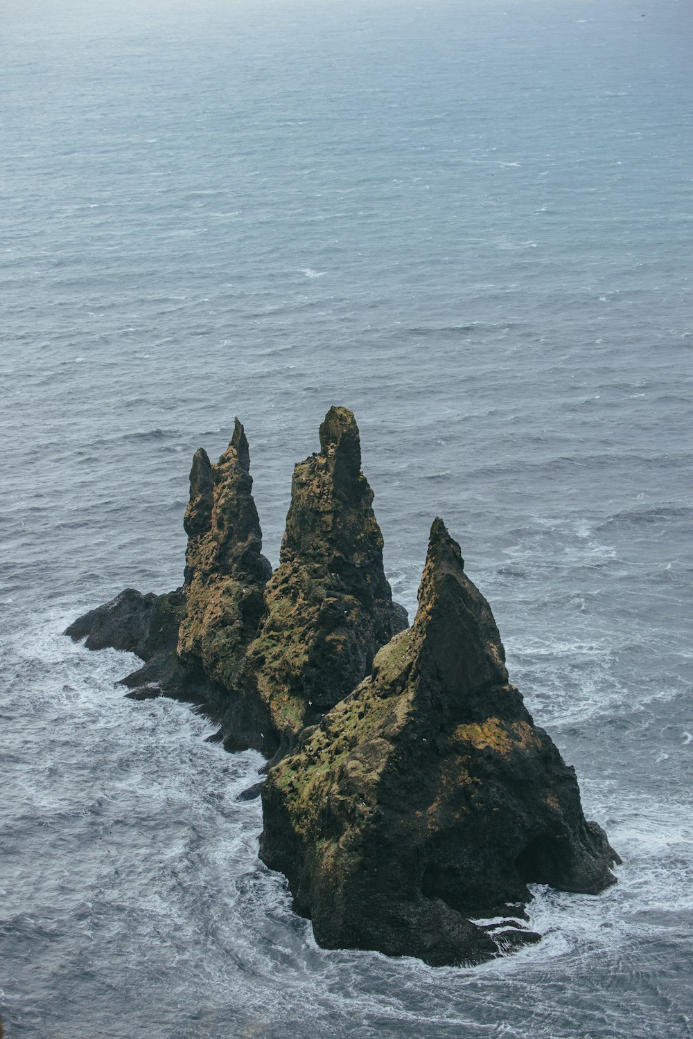 a group of rocks sticking out of the ocean