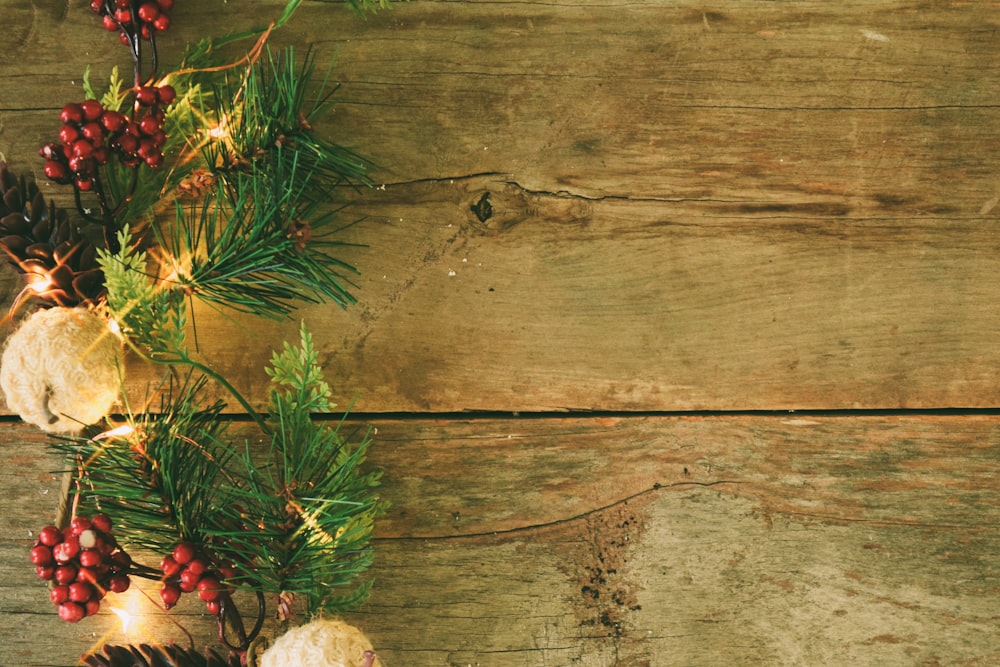 a wooden table topped with pine cones and berries