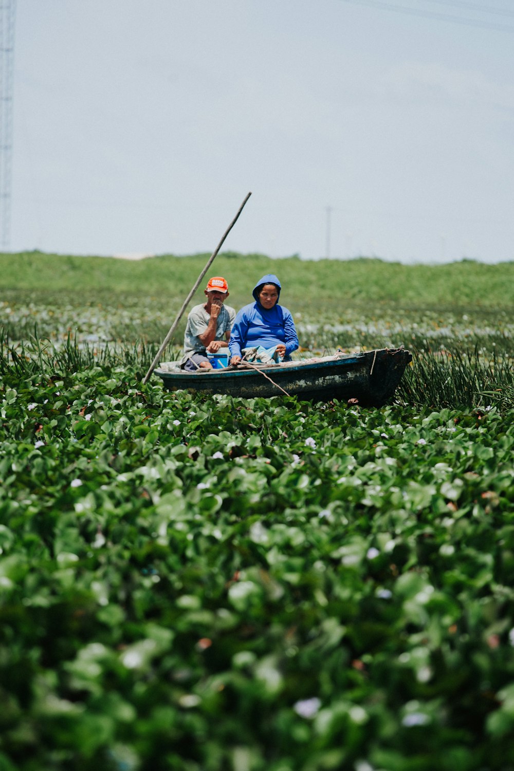 two people in a small boat in a field