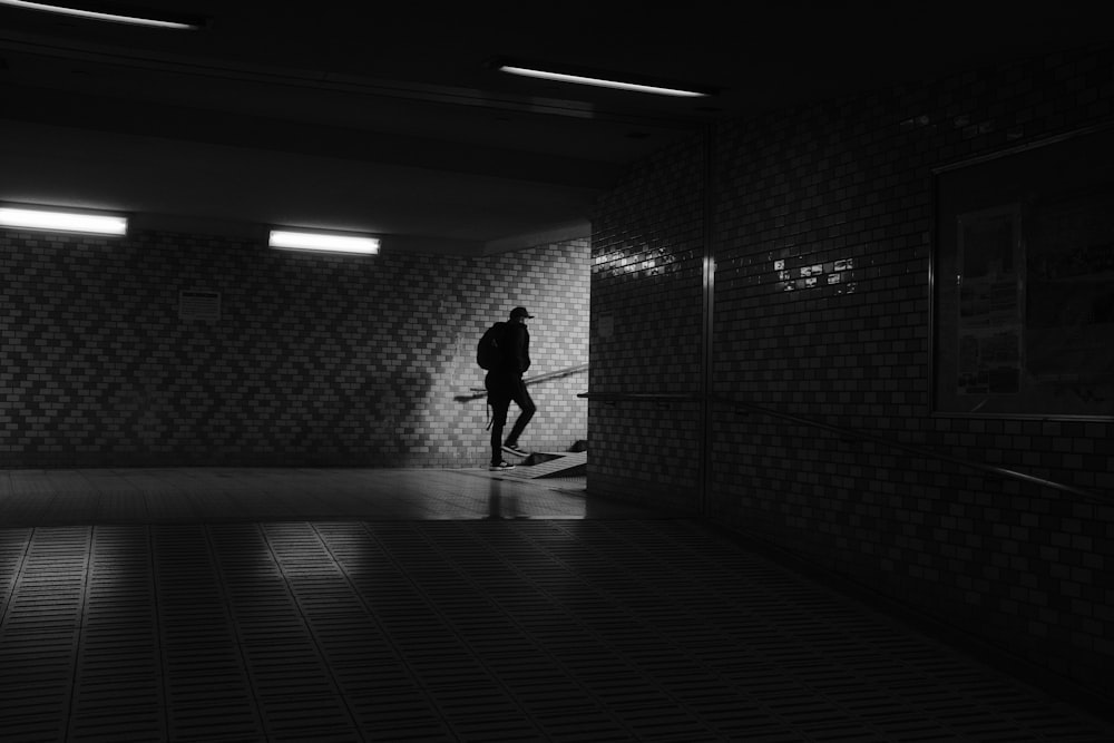a person standing in a dark room with a skateboard