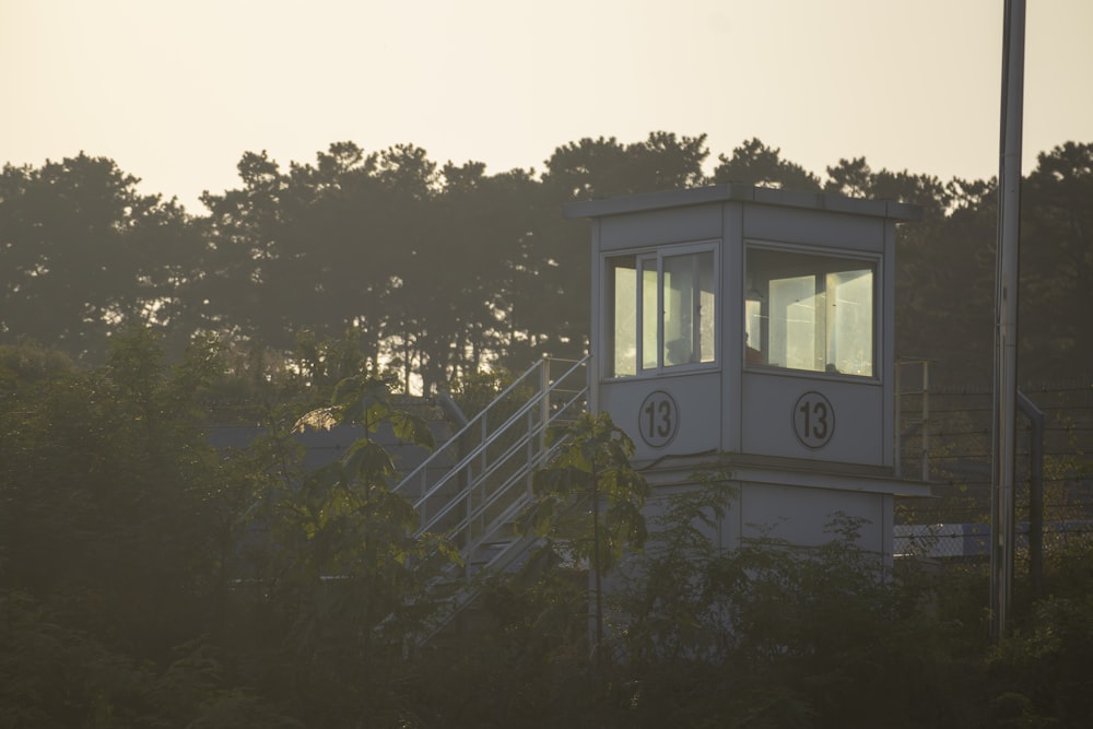 a white tower sitting in the middle of a forest