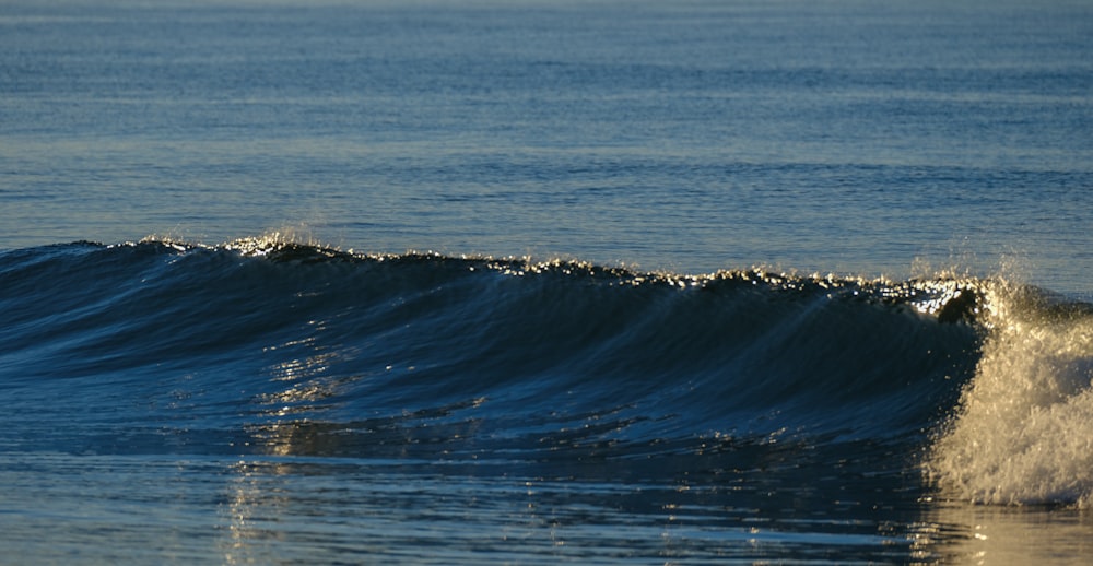 a man riding a wave on top of a surfboard