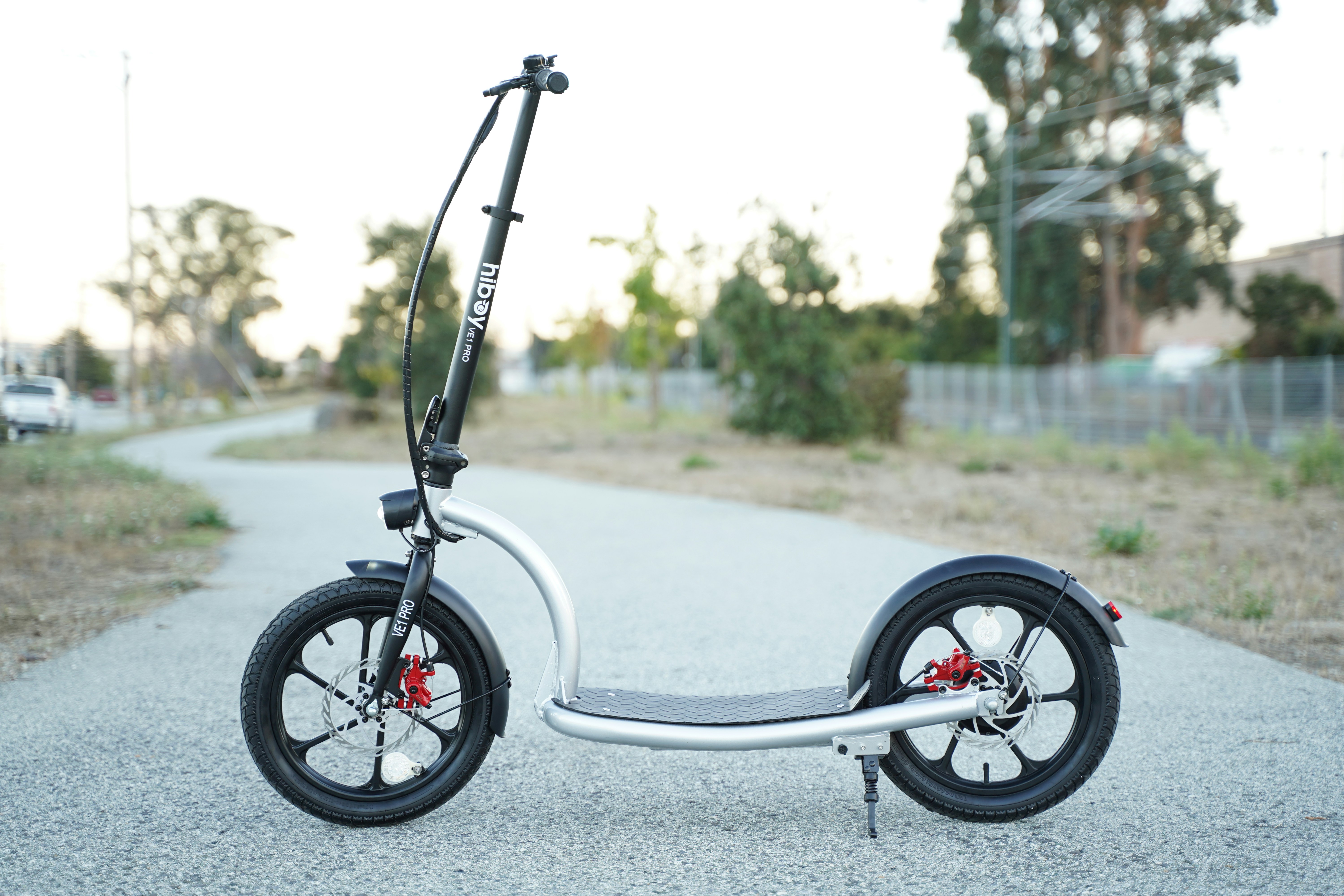 a scooter is parked on the side of the road, Our VE1 Pro electric scooter is the first big-wheel electric scooter. Its large 16-inch wheels and wide standing base make balancing easy and riding comfortable. https://www.hiboy.com/products/hiboy-ve1-pro-electric-scooter