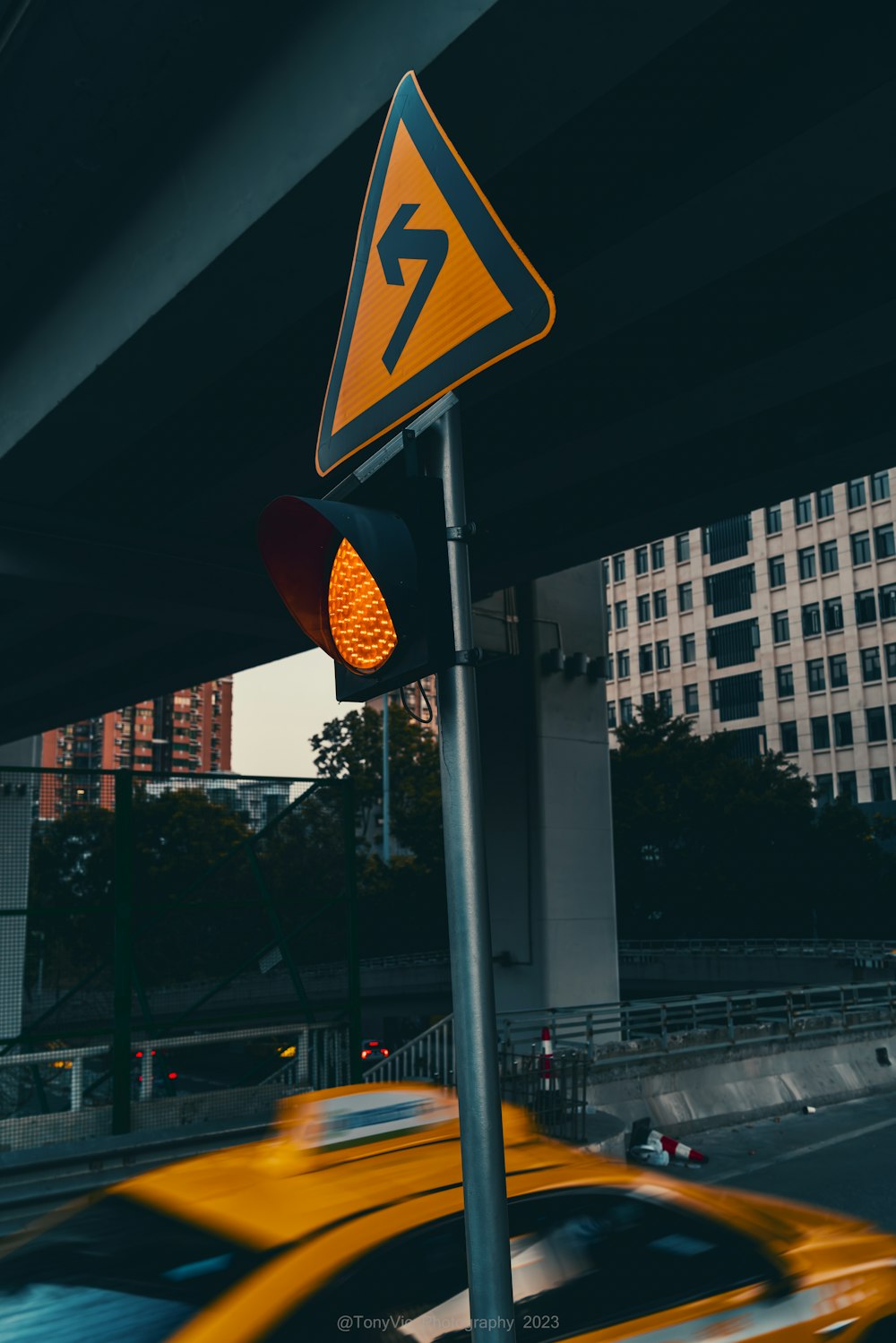 a traffic light sitting next to a yellow car