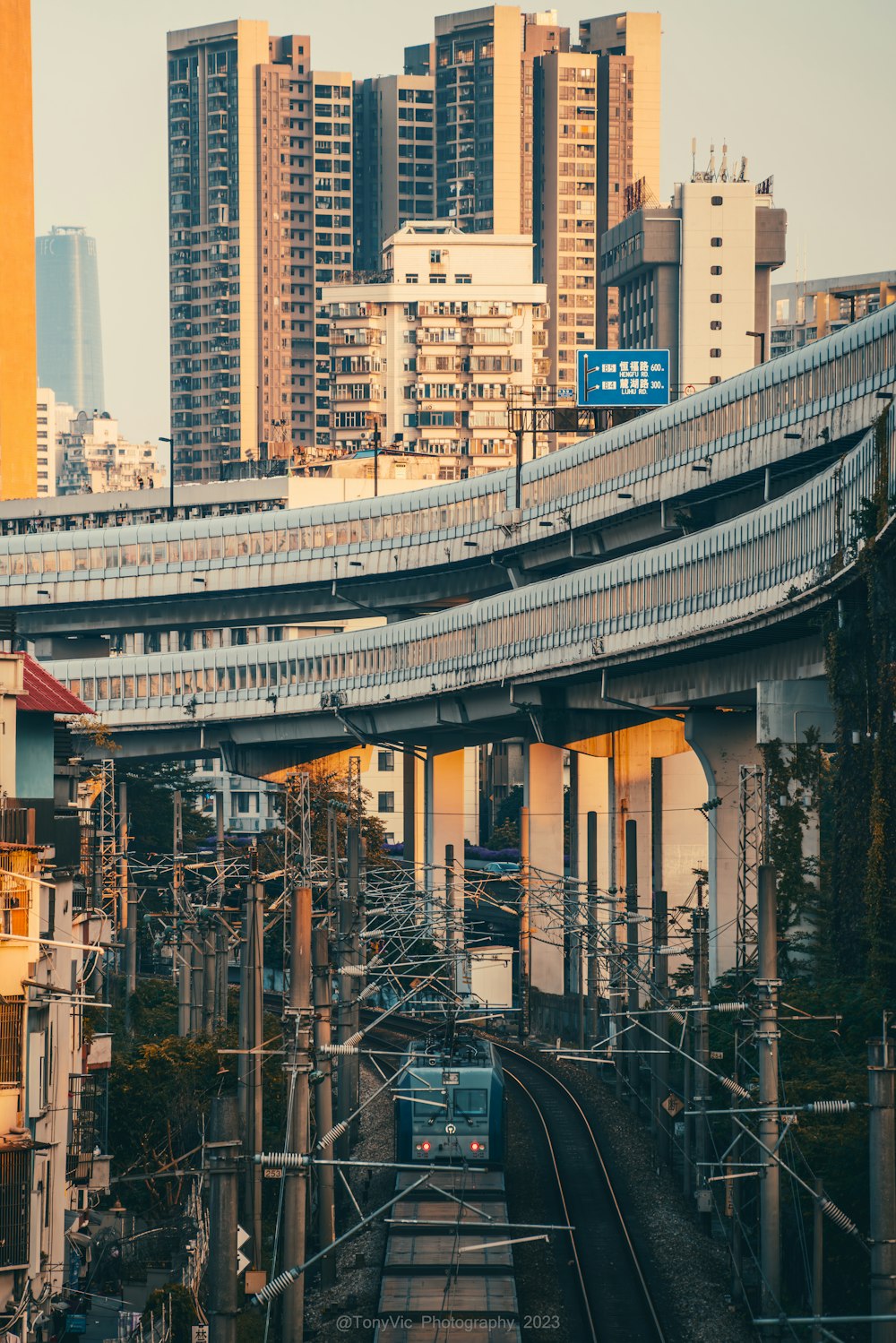 a train traveling down tracks next to tall buildings