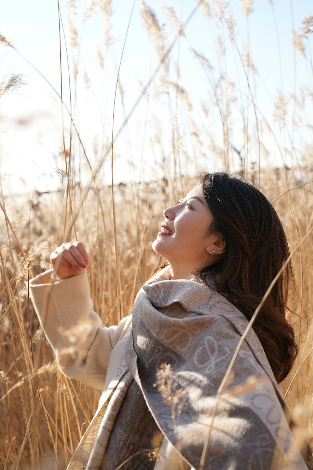 a woman standing in a field of tall grass