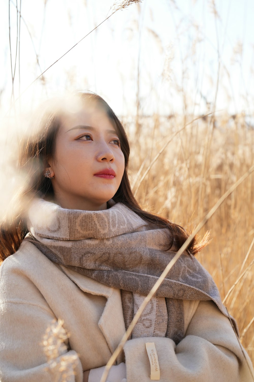 a woman standing in a field of tall grass