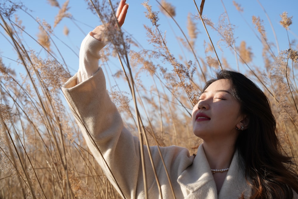 a woman standing in a field of tall grass