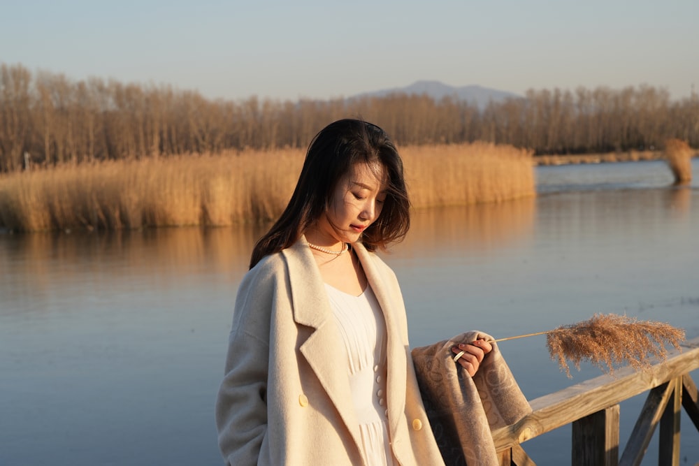 a woman standing on a bridge next to a body of water