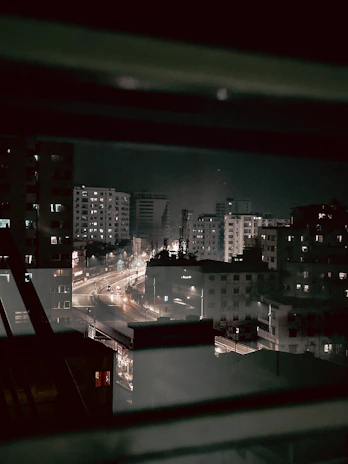 Nighttime cityscape glimpse from the hotel window, capturing the calm urban atmosphere.