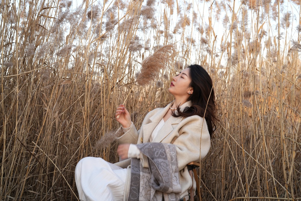 a woman sitting in a field of tall grass