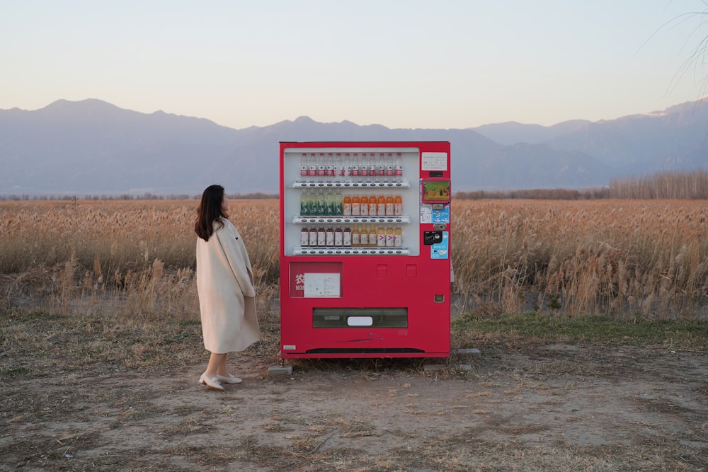 a woman standing in front of a vending machine