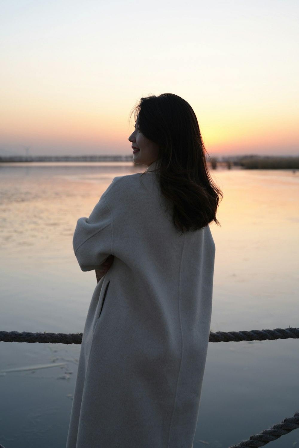 a woman standing on a boat looking out at the water