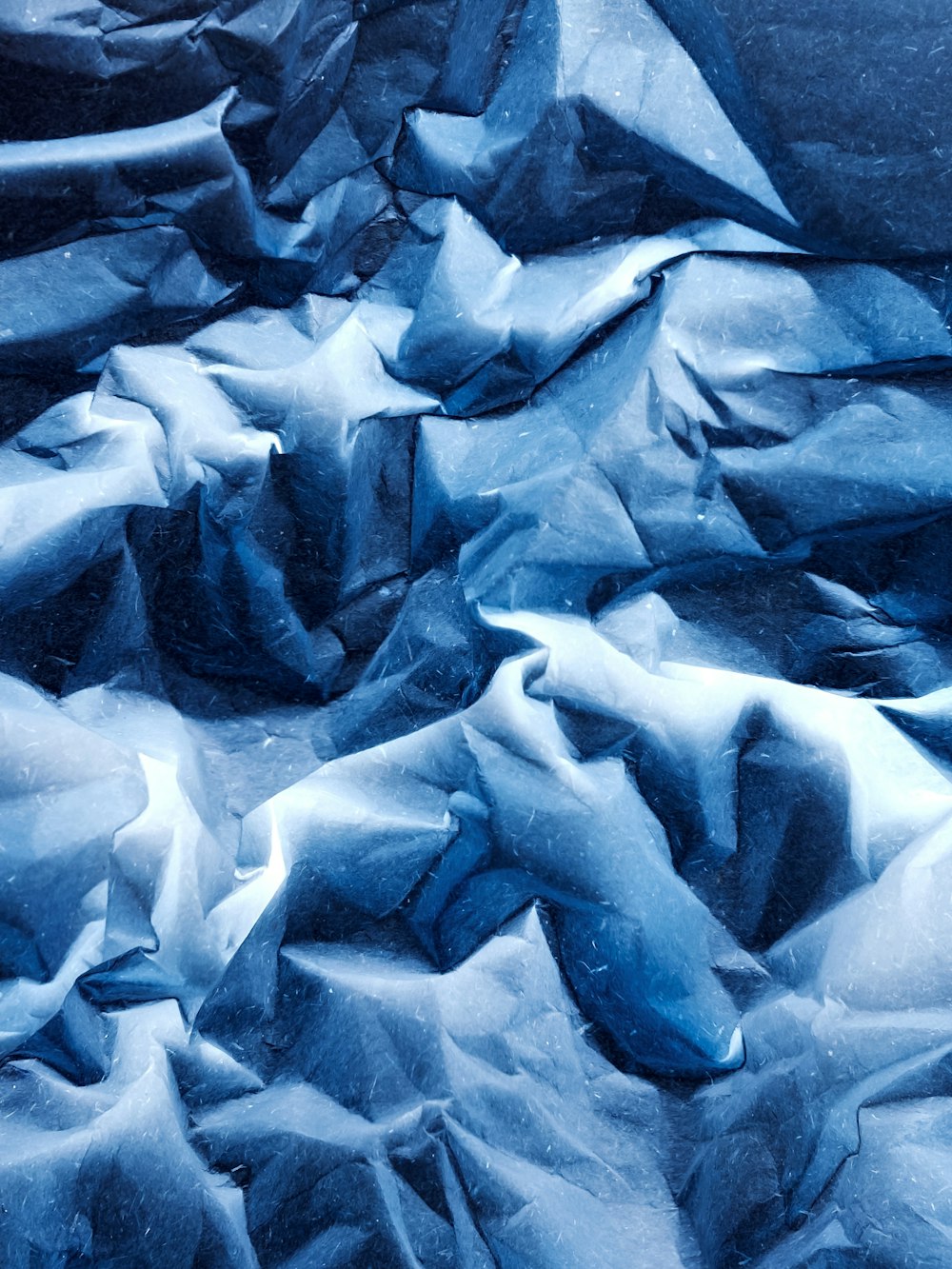 a pile of blue paper sitting on top of a bed