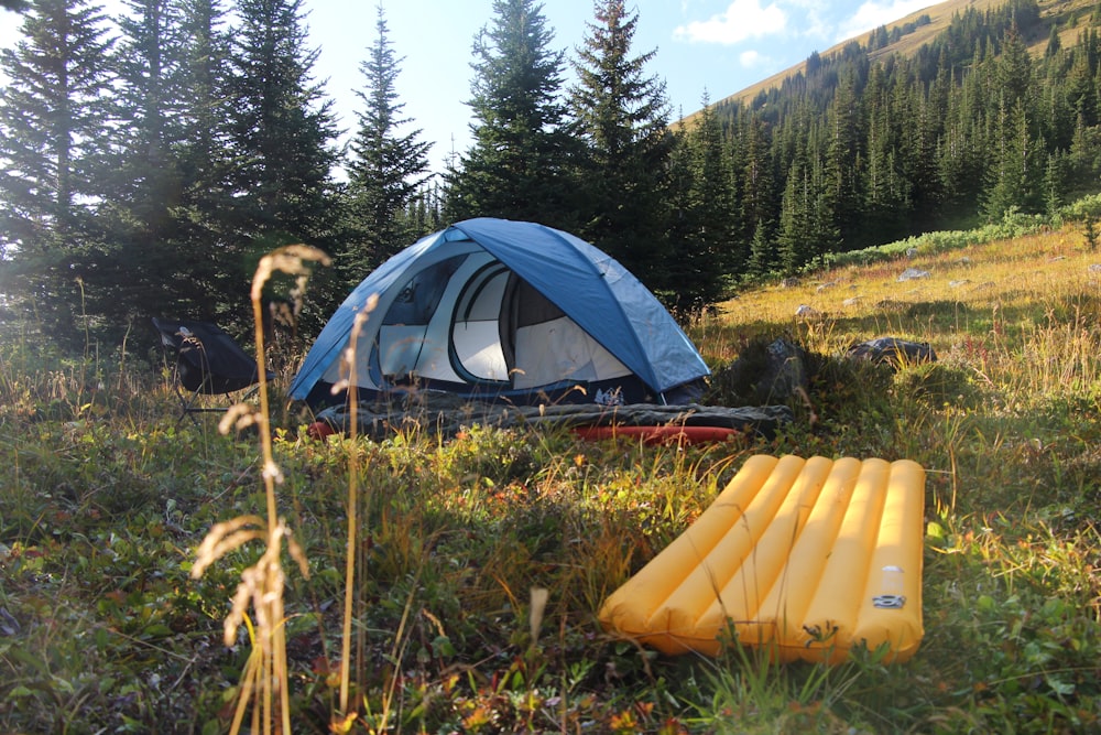 a tent in the middle of a field with an inflatable mattress