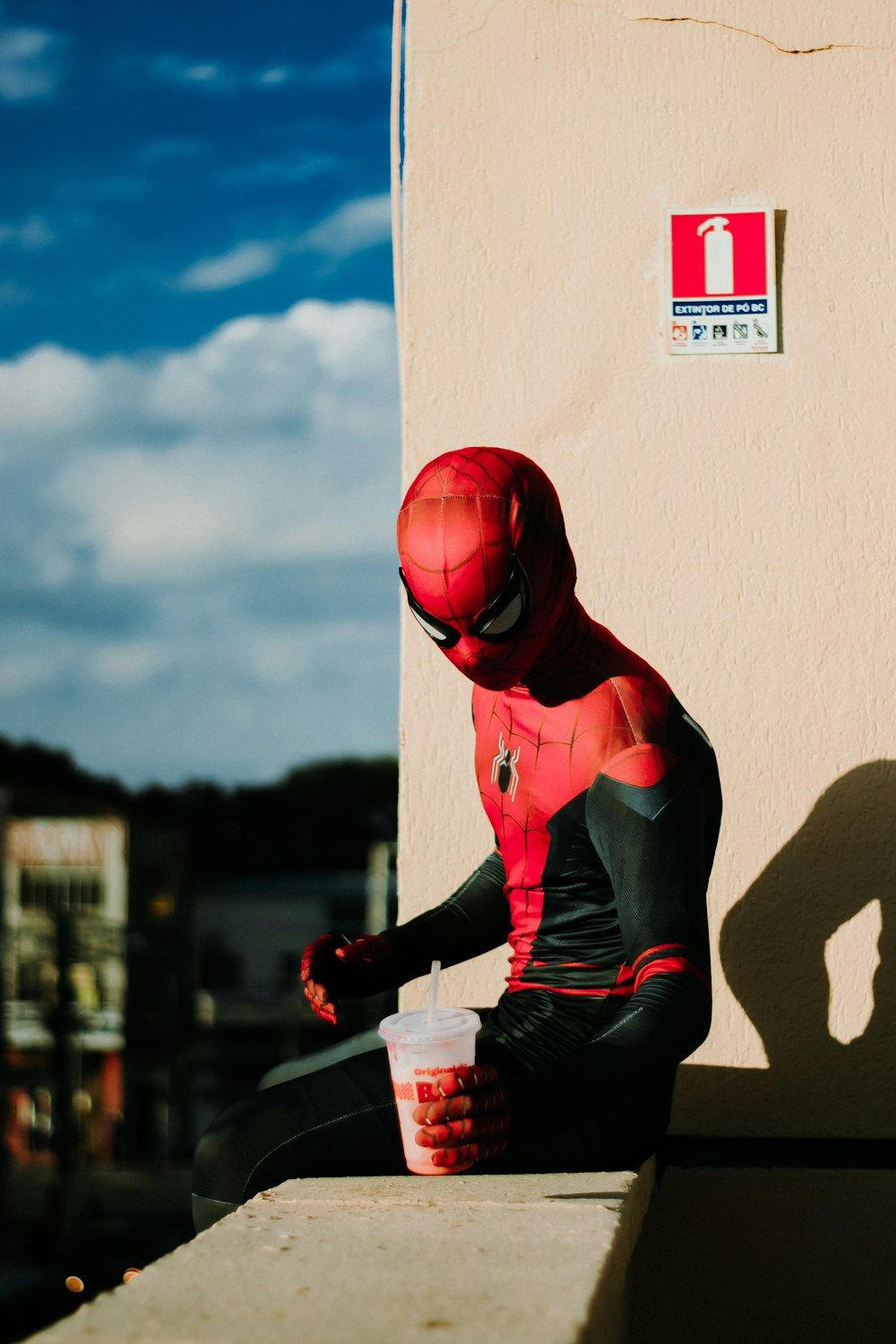 a man in a spider suit sitting on a ledge