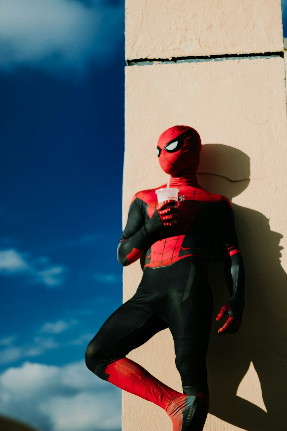 a spider man standing next to a building
