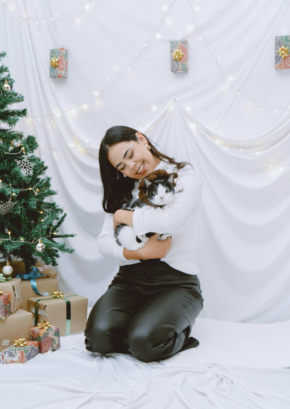 a woman sitting on a bed holding a cat