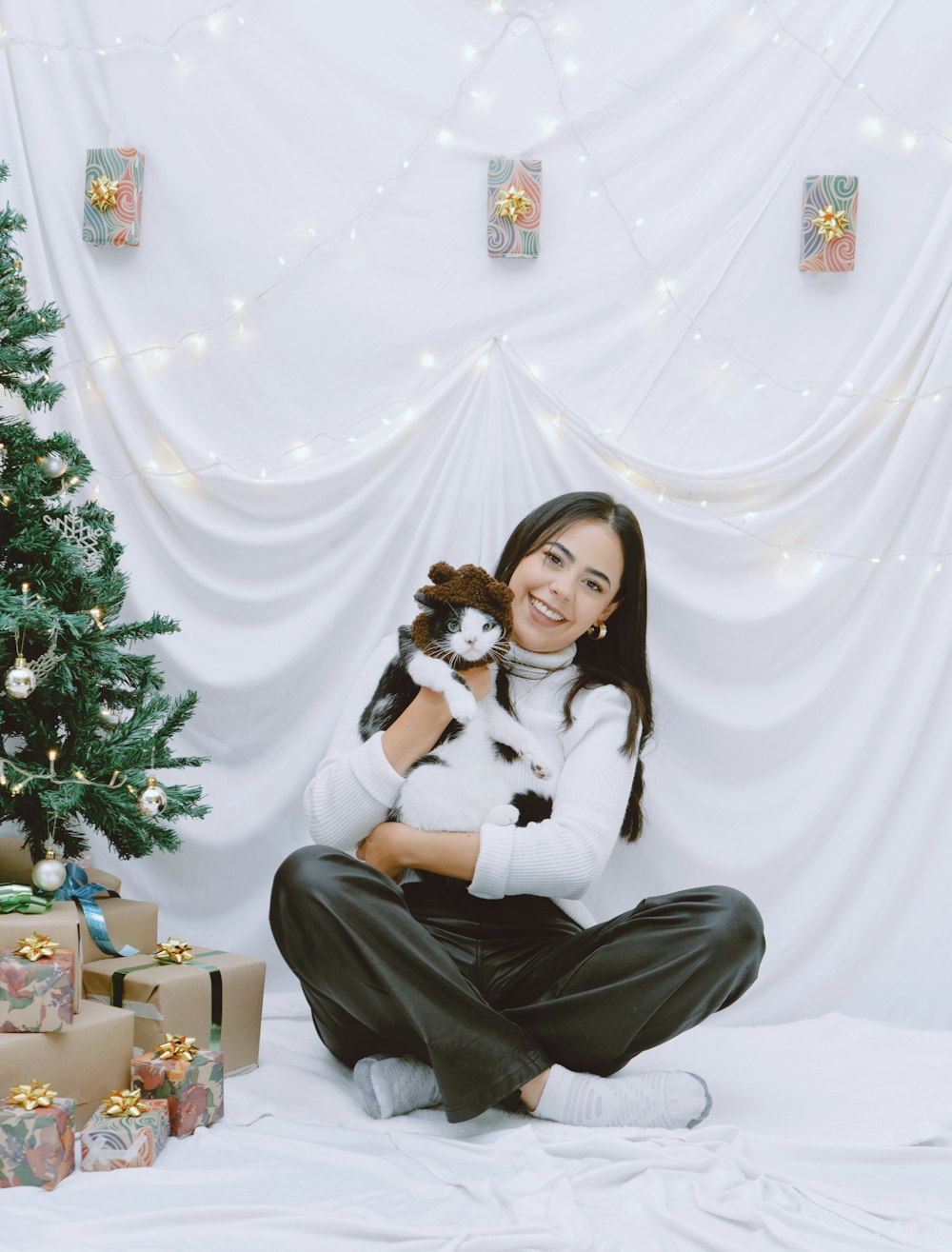 a woman sitting on a bed holding a dog