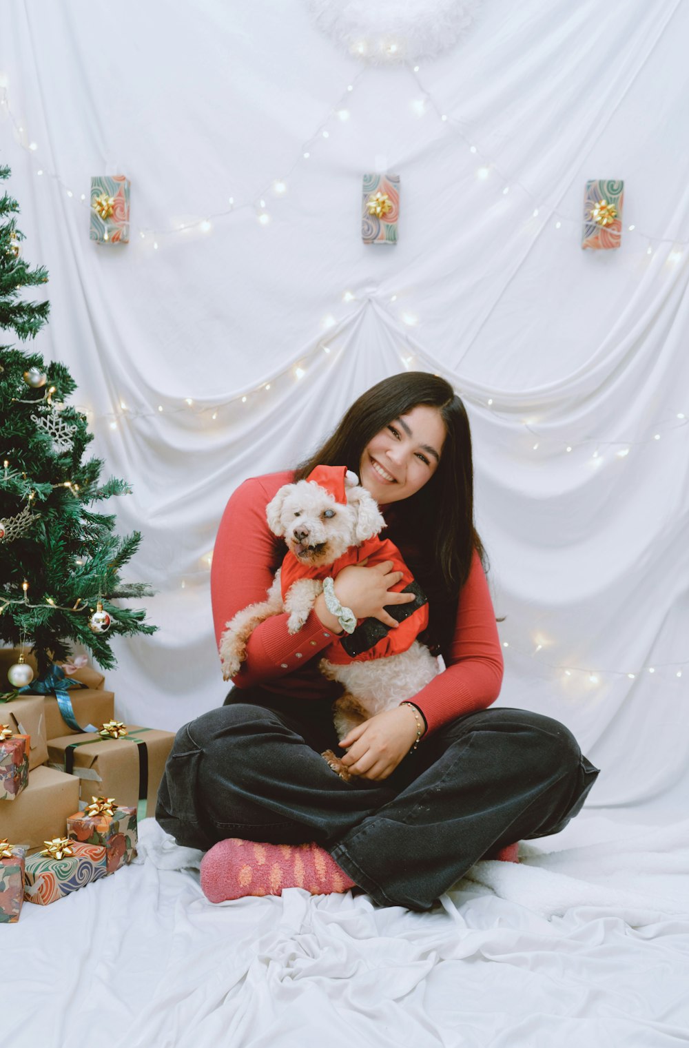 a woman sitting on a bed holding a dog