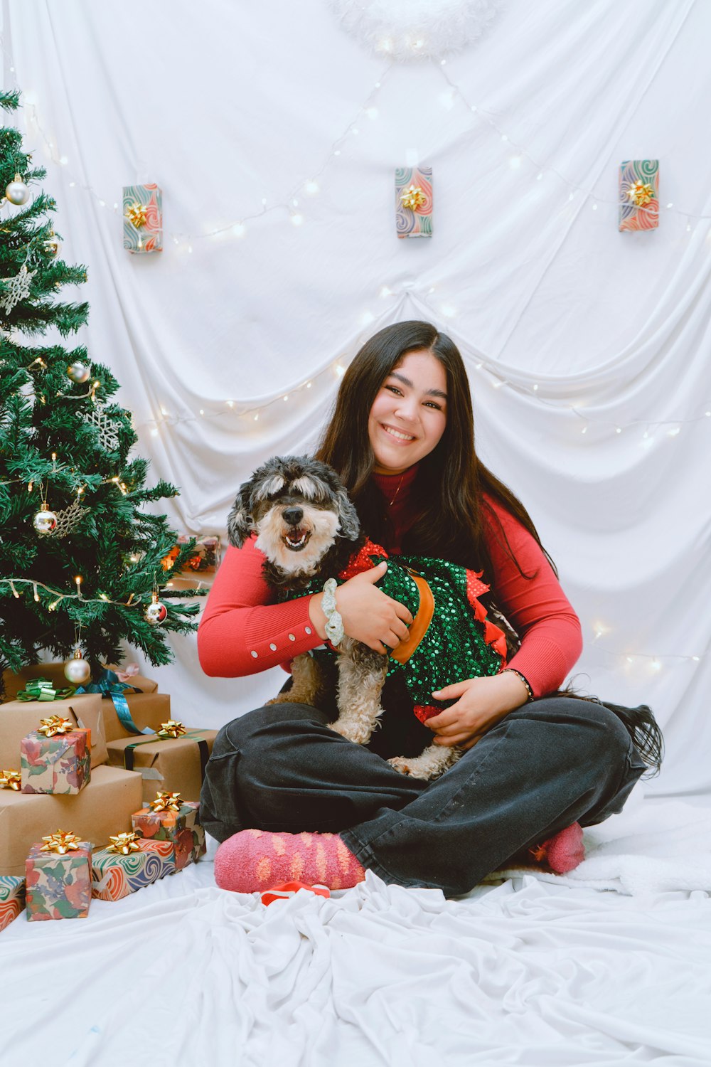 a woman sitting on a bed holding a dog