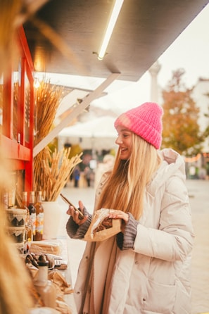 Smiling customers enjoying pastries at a cozy outdoor market stall.