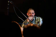 George in deep concentration at the microphone, wrapped in a navy indigo shawl.