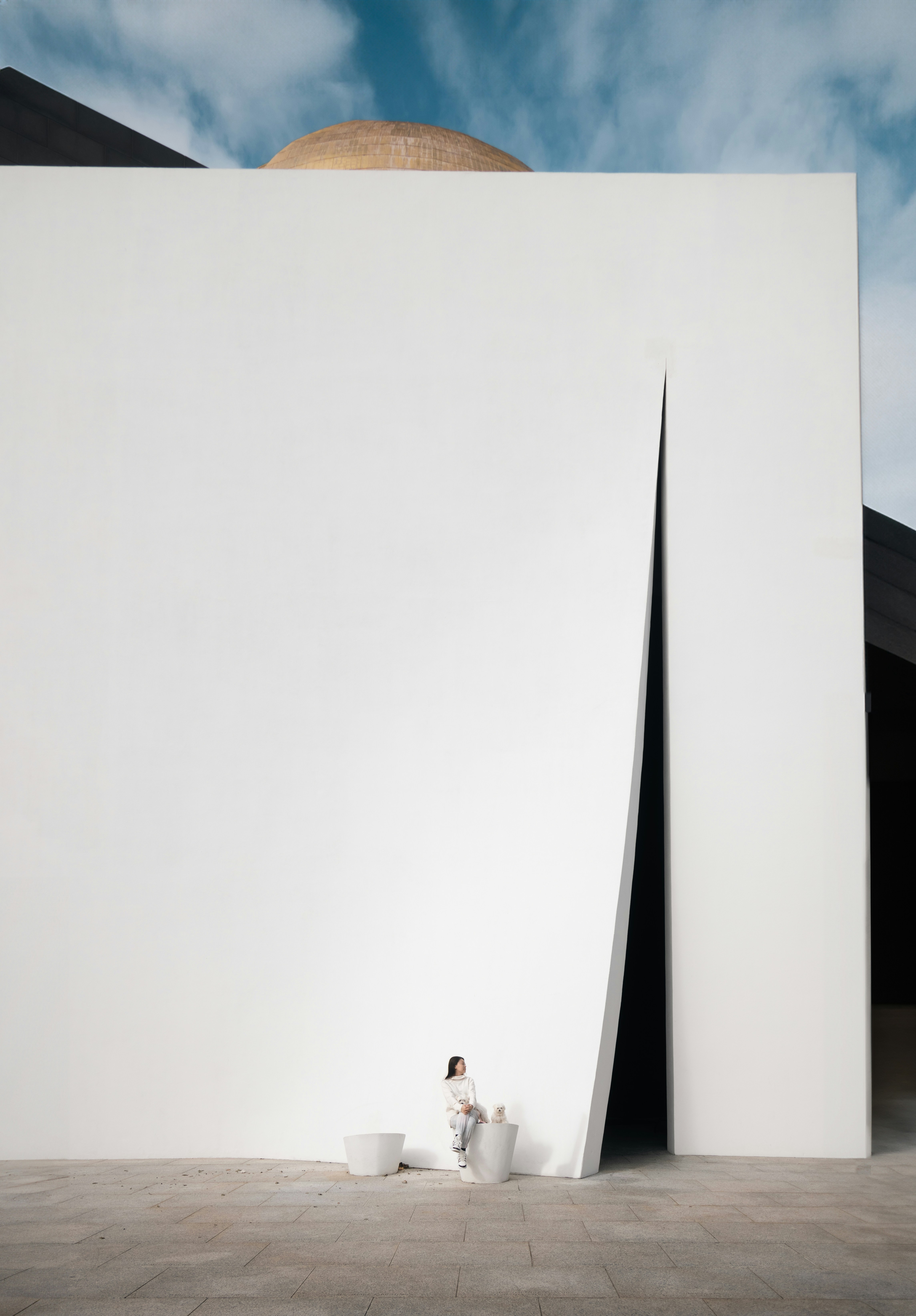 a person sitting in front of a white building