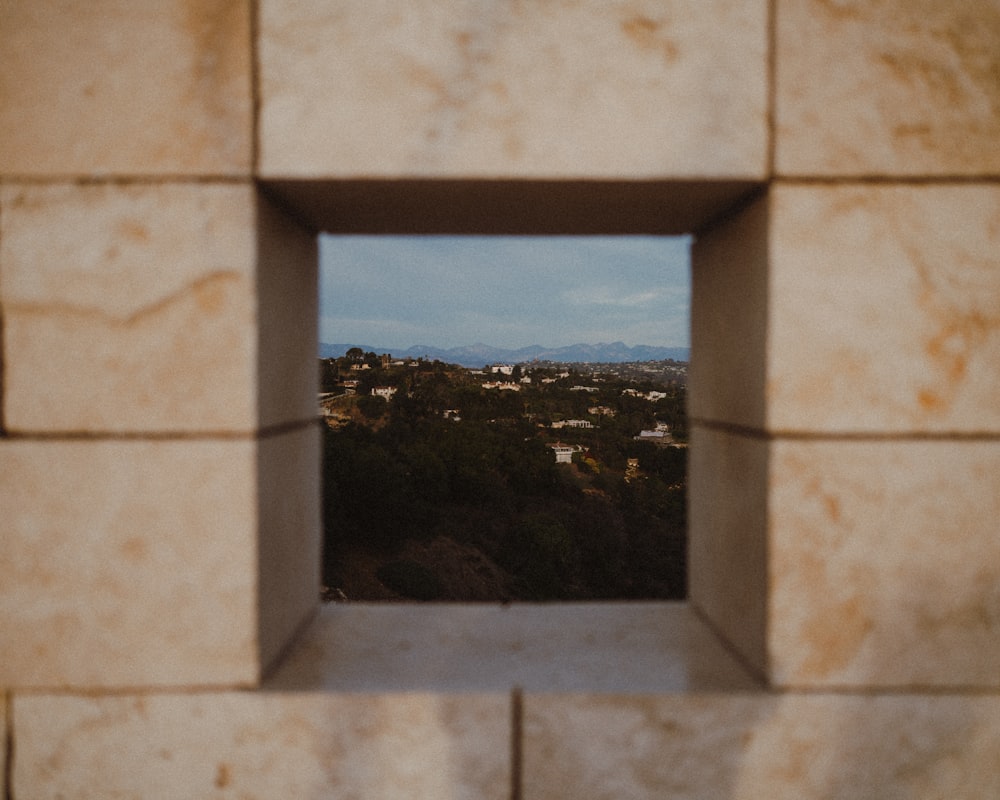 a view of a city through a window in a wall
